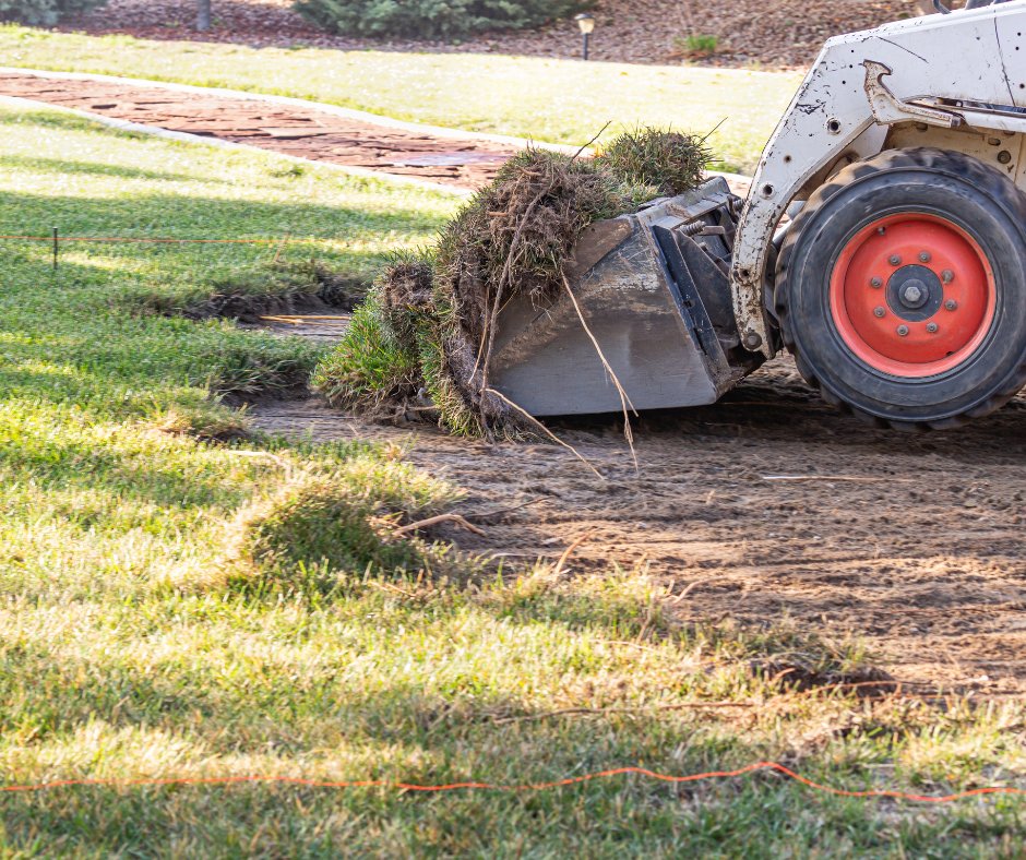 Professional landscaping equipment in action, clearing a yard for a new landscape design.