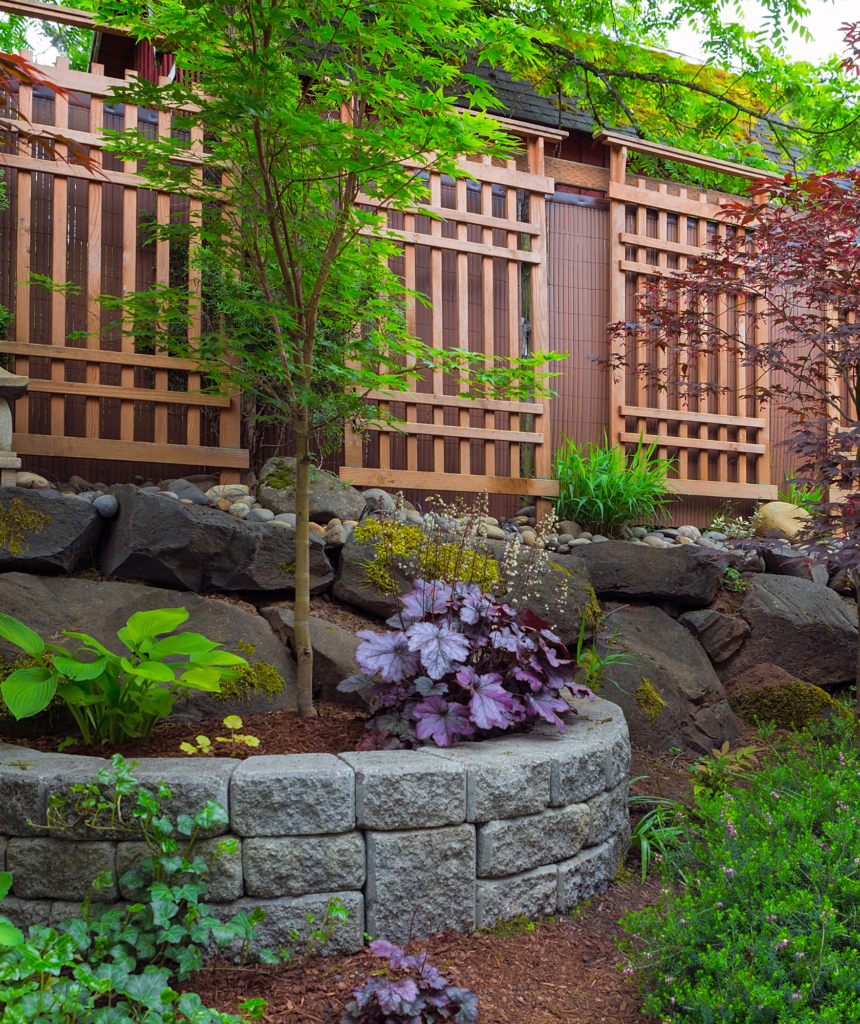 Serene Backyard Oasis with Retaining Wall and Japanese-Inspired Fence