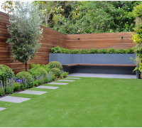 Residential landscaping design featuring a cozy seating area and lush greenery.